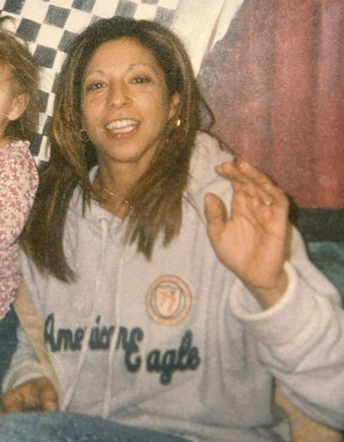 Woman smiling and waving in casual setting, related to New England serial assassination case.