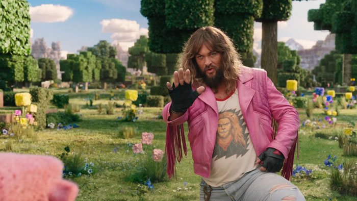 Person in a vibrant Minecraft-themed landscape, wearing a pink jacket, possibly related to a new movie trend.