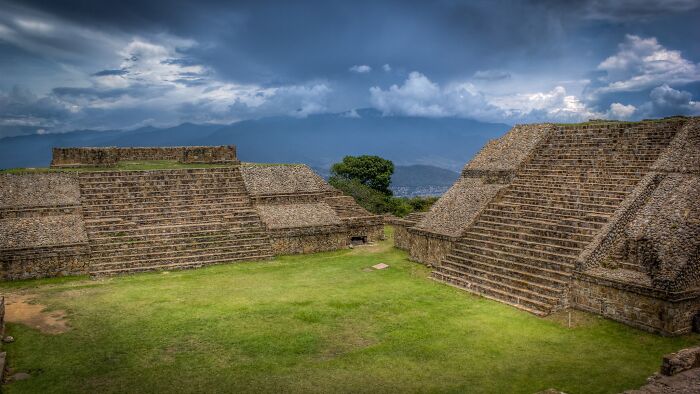 Ancient stone pyramids under a cloudy sky, showcasing lesser-known architectural wonders.