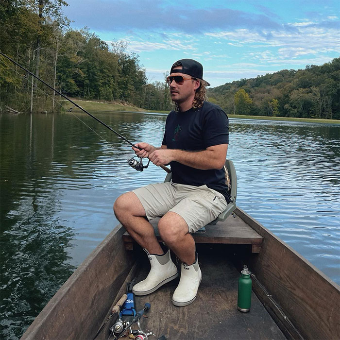 Morgan Wallen fishing on a lake, showcasing a relaxed moment. Morgan Wallen fishing on a lake, showcasing a relaxed moment.