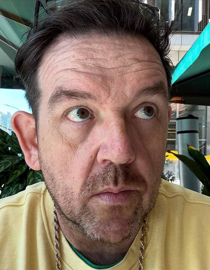 Man in a yellow shirt looking up, amidst fan backlash for playing Hagrid in Harry Potter series.