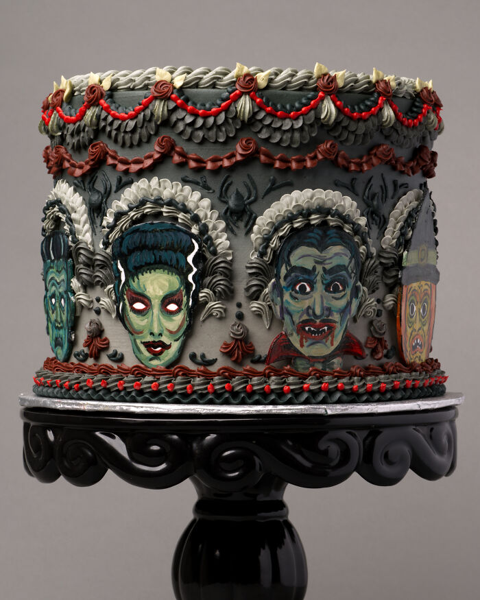 A visually stunning cake featuring intricate monster faces, with gothic colors and detailed decoration.
