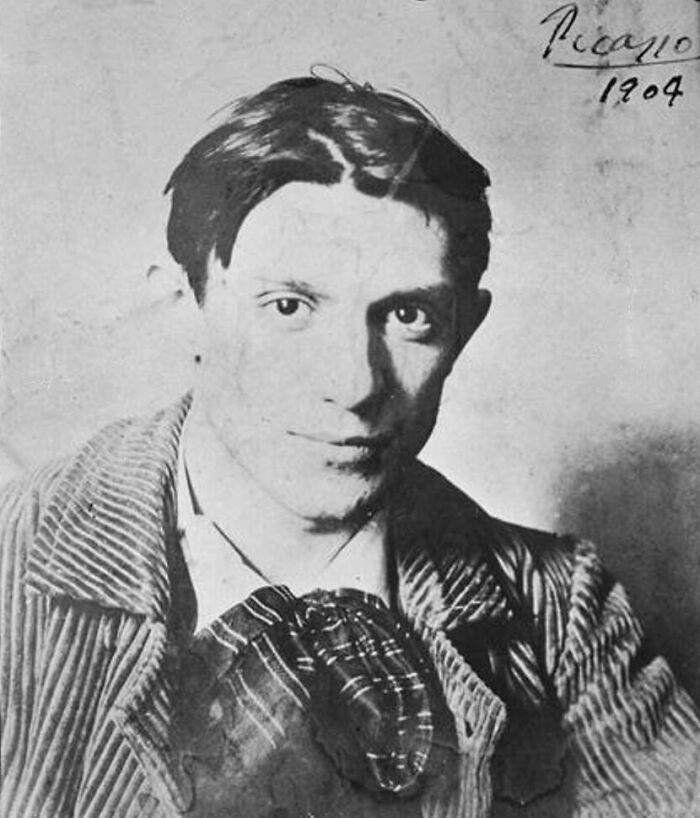 Black and white rare photo of a famous historical figure from the early 1900s wearing a striped jacket and patterned scarf.