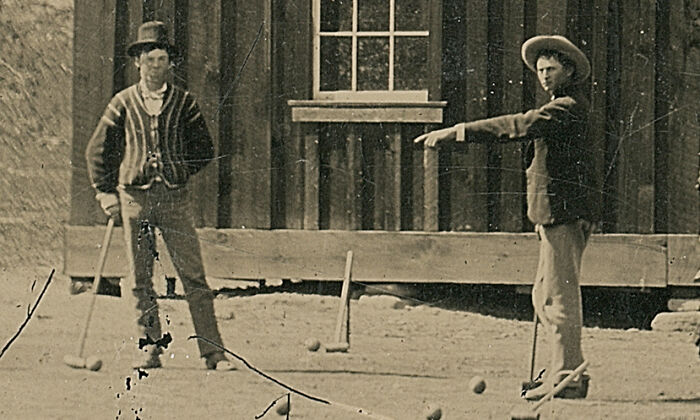 Two famous historical figures playing croquet outside a wooden building in a rare vintage photo.