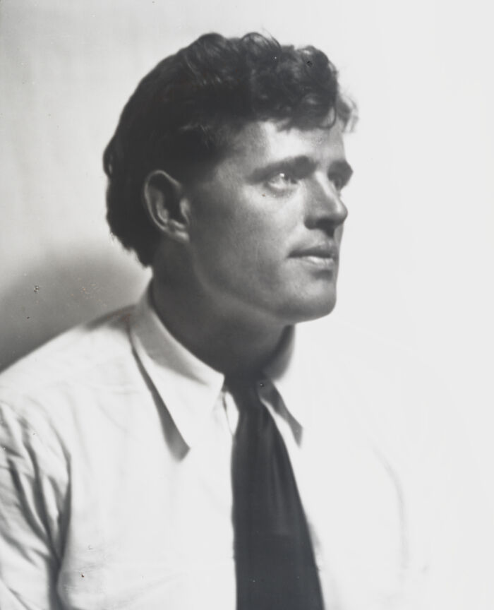 Black and white portrait of a famous historical figure with curly hair, wearing a white shirt and dark tie.