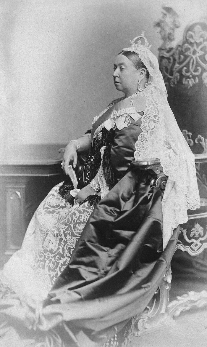Rare photo of a famous historical figure, Queen Victoria, seated in ornate royal attire with lace and a crown.