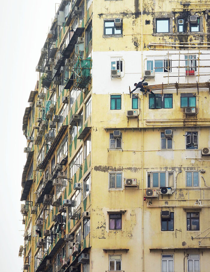 Reaching Out, 2024 - A Man Is Reaching Out To Grab A Part Of A Dismantled Scaffolding