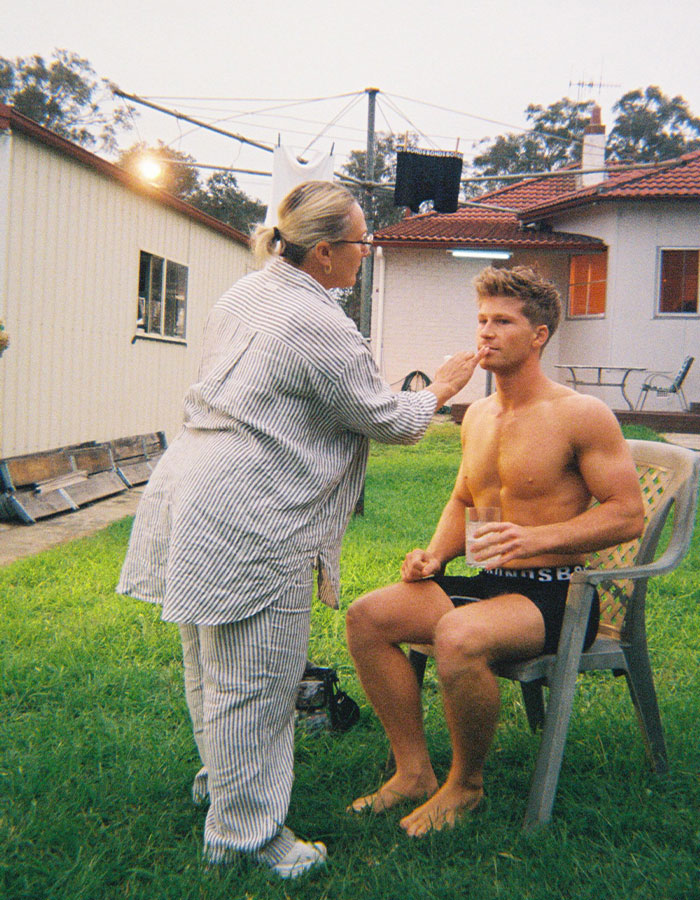 Shirtless man sitting outdoors with drink, being prepared for photoshoot, Robert Irwin's racy photoshoot context. Shirtless man sitting outdoors with drink, being prepared for photoshoot, Robert Irwin's racy photoshoot context.