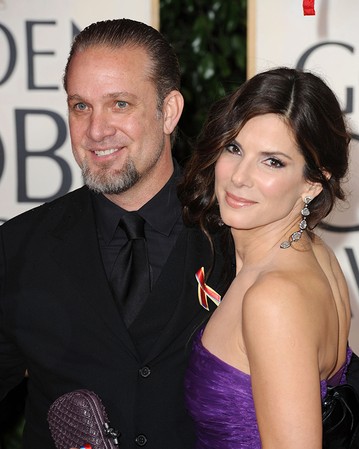 Couple at a glamorous event, tied to Hollywood scandals, wearing elegant attire and posing together on the red carpet.