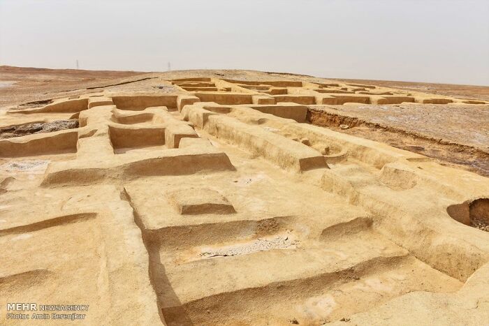 Excavated ancient man-made structures reveal complex layouts in a desert landscape, showcasing early human engineering.