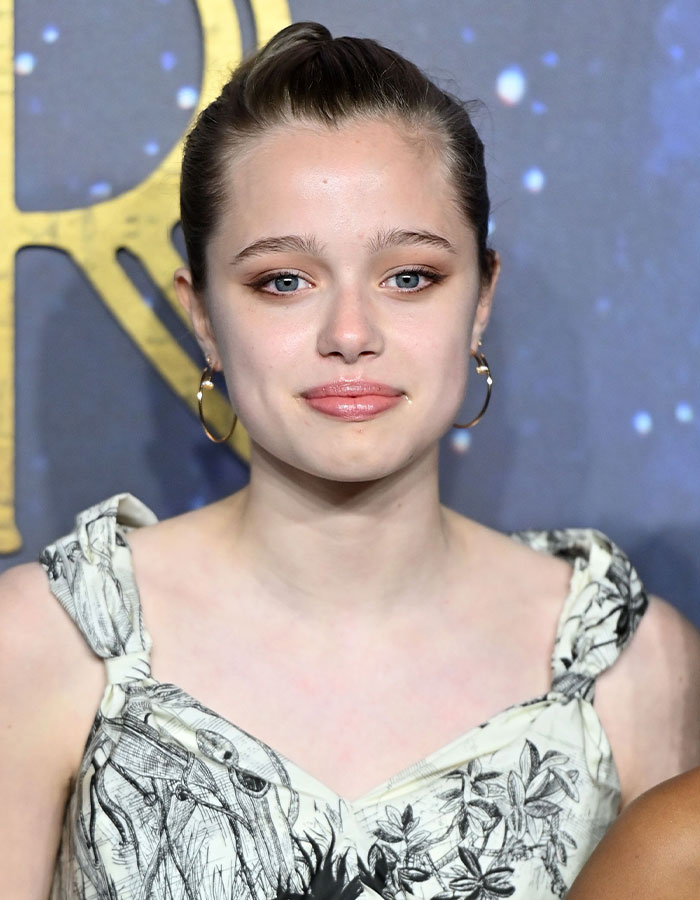 A person in a floral dress and hoop earrings at a public event, representing a stunning transformation. A person in a floral dress and hoop earrings at a public event, representing a stunning transformation.