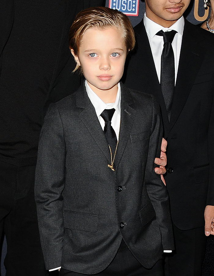 Child in a formal suit at an event, showcasing a striking transformation. Child in a formal suit at an event, showcasing a striking transformation.