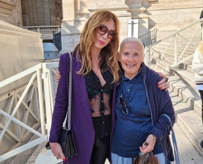 Woman in sunglasses posing with another woman in blue, related to viral nun story with Pope Francis.