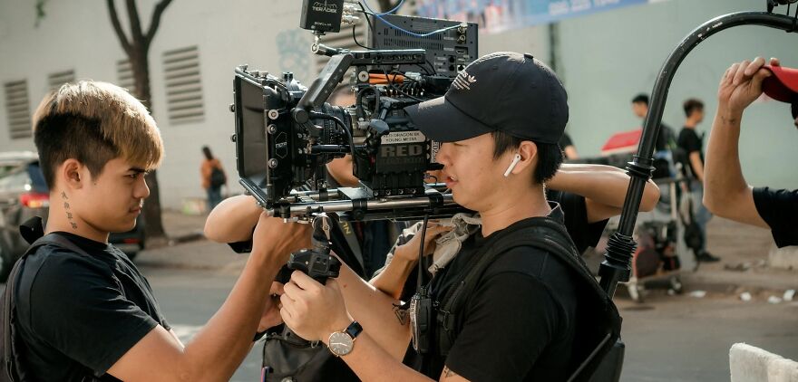Crew setting up a camera on a film set, capturing ethical dilemmas in filmmaking.