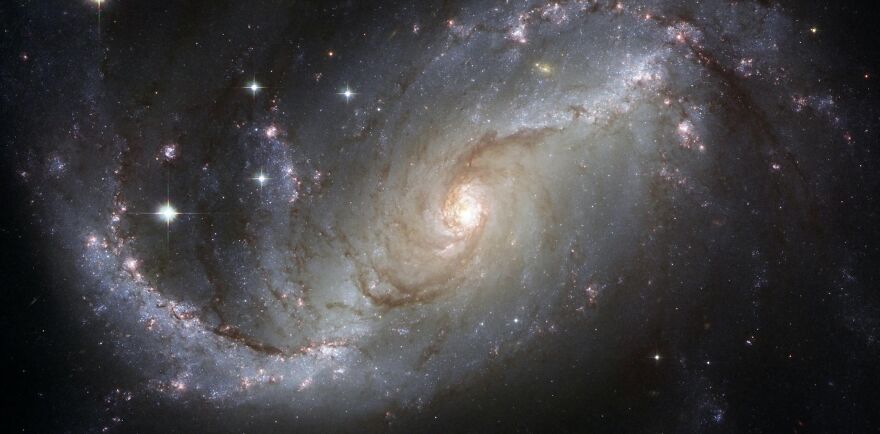 Spiral galaxy swirling with stars and dust, evoking cosmic ethical dilemmas.
