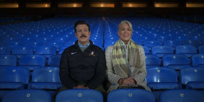 Two characters sitting in empty blue stadium seats, representing a show maintaining 10/10 quality throughout.
