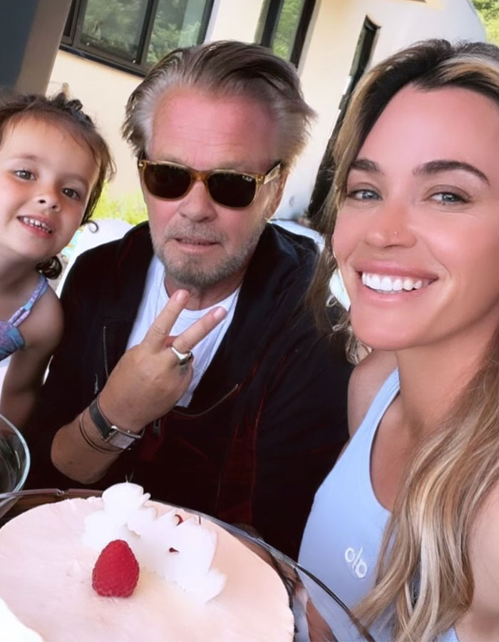 A smiling family moment with Teddi Mellencamp, her dad, and a child outdoors.