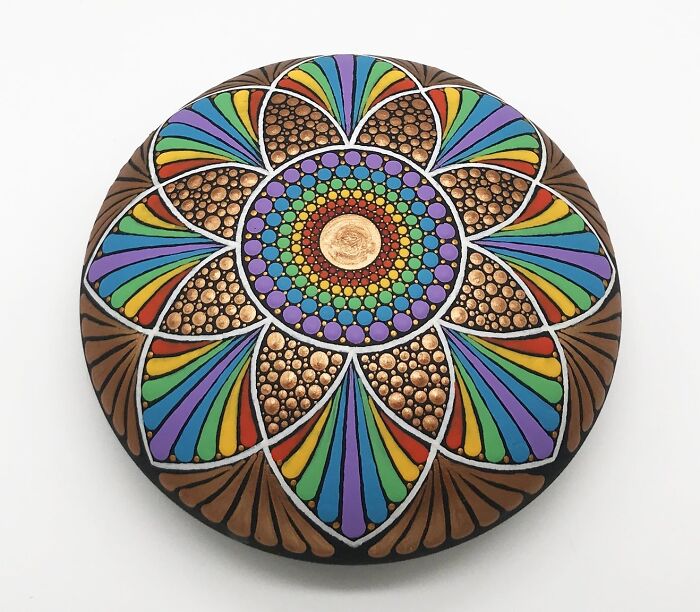 Colorful mandala art intricately painted on a stone, showcasing a mesmerizing design with vibrant patterns.