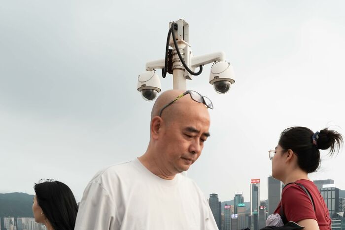 Man standing near security cameras, creating a lucky coincidence of perfectly timed alignment.