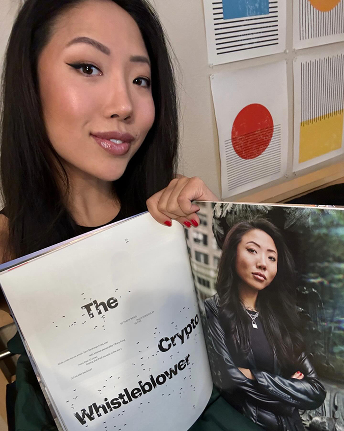 Woman holding a magazine featuring an article titled "The Crypto Whistleblower.