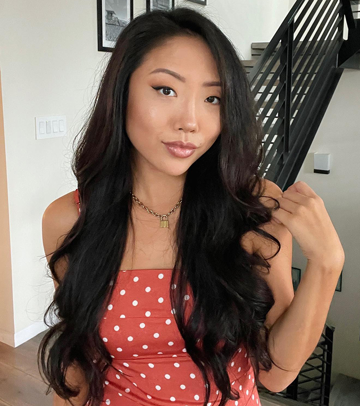 Young woman posing indoors, relating to Elon Musk controversy with right-wing influencer.