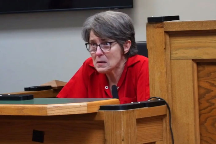 Woman in court, wearing a red shirt, visibly upset during sentencing related to infant care incident. Woman in court, wearing a red shirt, visibly upset during sentencing related to infant care incident.