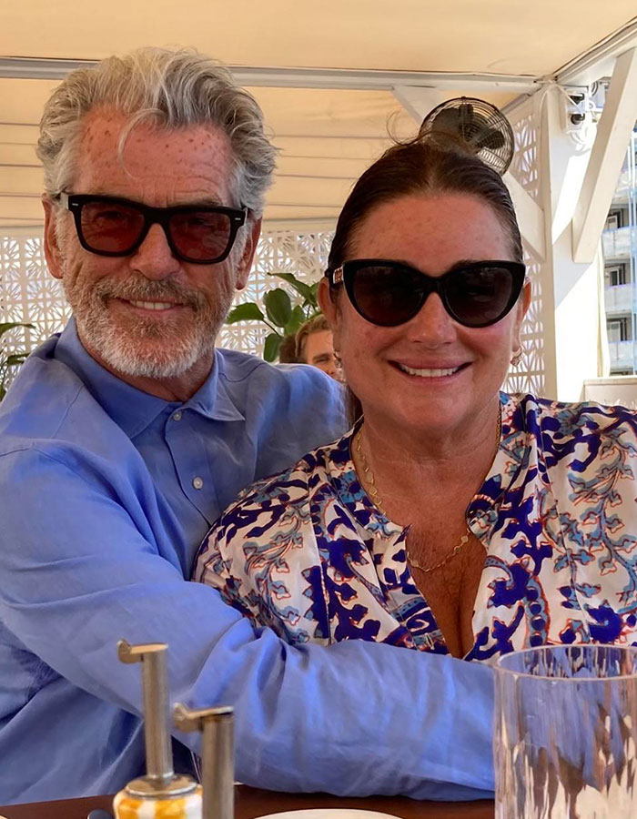 Couple smiling together in sunglasses, embracing warmly, in a bright, relaxed setting. Couple smiling together in sunglasses, embracing warmly, in a bright, relaxed setting.