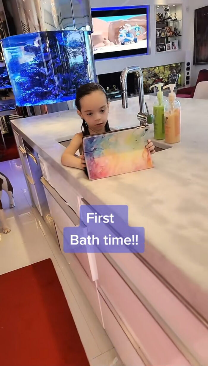Young child holding a colorful tablet in a modern kitchen, related to celebrity encounters that went well or badly.