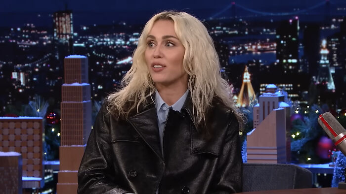 Blonde woman in a black leather jacket speaking on a talk show about horrifying times celebrity homes were broken into.