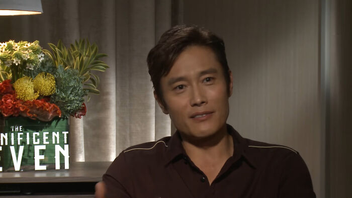 Actor speaking in an interview setting with flowers in the background related to celebrity homes broken into stories.