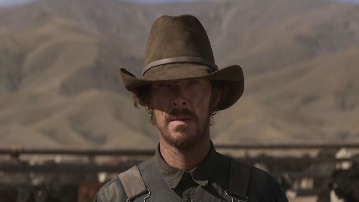 Actor wearing a wide-brimmed hat portraying a challenging role in a rugged outdoor setting for difficult roles.