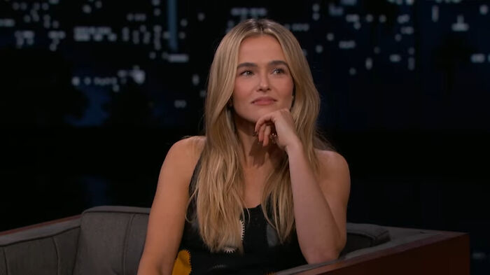 Blonde woman sitting in a dark studio setting, contemplating stories about celebrity homes being broken into.