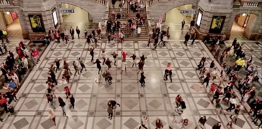 Crowd participating in a viral trend in a large indoor space, viewed from above.