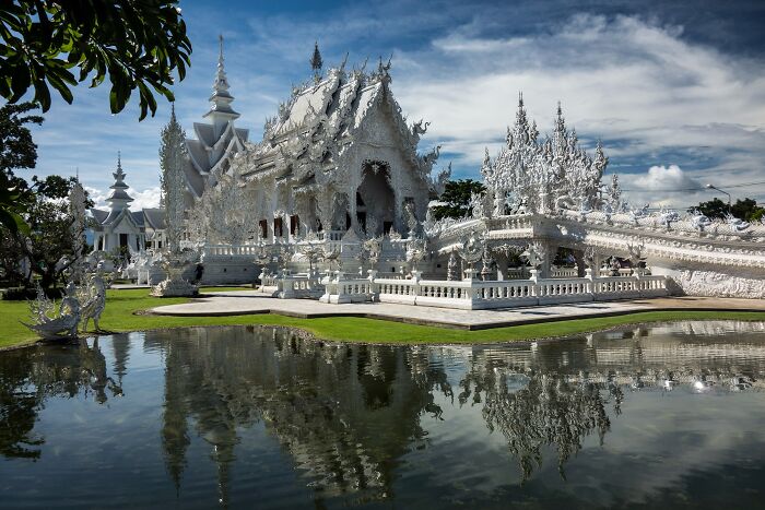 Ornate white temple reflected in a serene pond, showcasing one of the architectural wonders not very well-known.