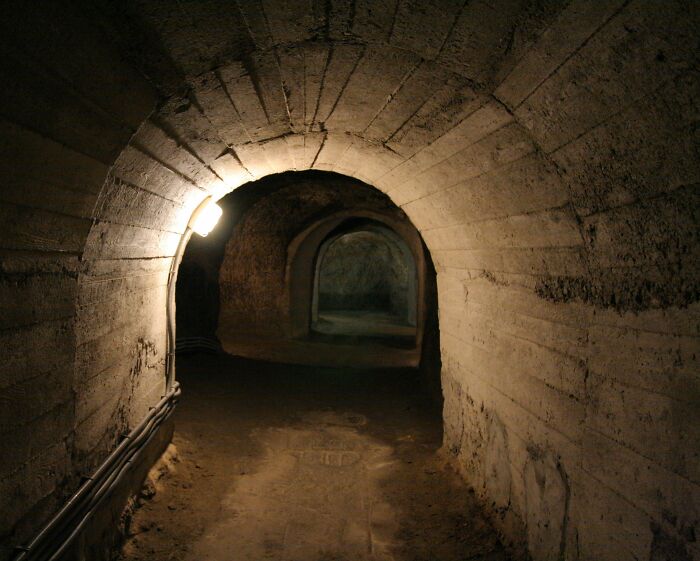 Dimly lit underground tunnel in an eerie city built below ground.