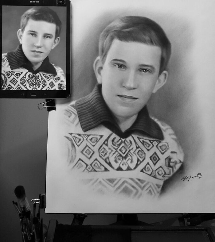 Hyper-realistic pencil portrait of a young man beside its reference photo on a tablet.