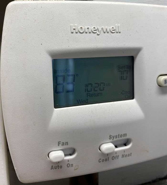 Thermostat displaying 83°F, set to 70°F, highlighting infuriating bosses in workplace temperature control.