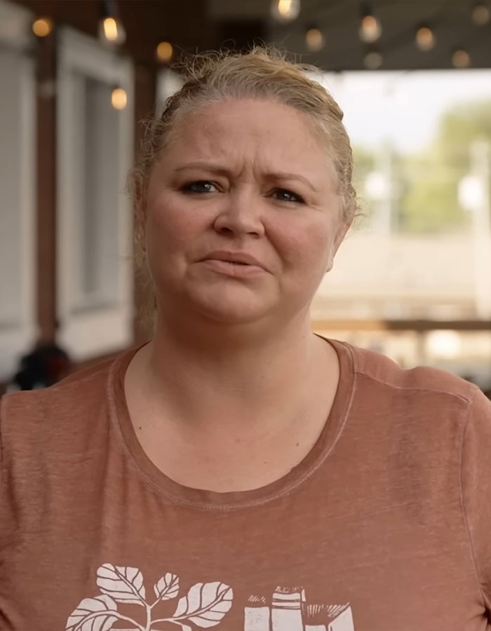 Woman outside in a casual setting, expressing mixed emotions, highlighting a 500-pound transformation journey.