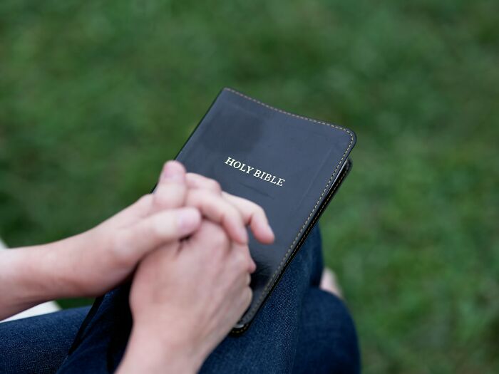 Hands clasped over a Bible, highlighting relationship issues and marriage challenges.