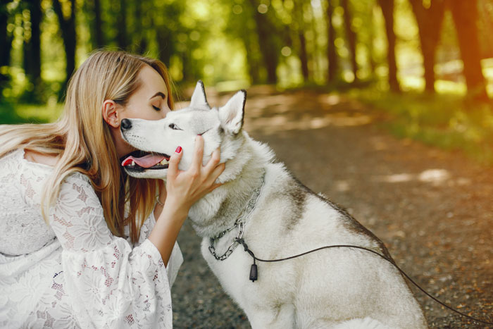 Woman hugging an adopted dog in a park, highlighting a spouse spat over the dog's behavior.