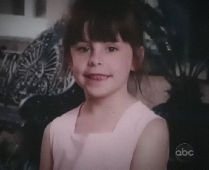 Childhood photo related to son who sent mom to prison, smiling girl in a pink dress.