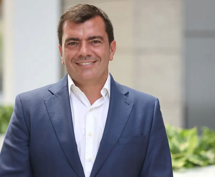 Smiling man in a suit, associated with New York helicopter crash victims news.