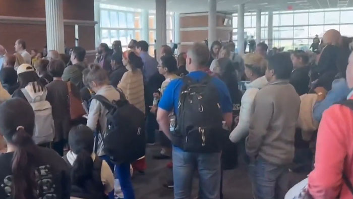 Delta passengers stand in a crowded airport terminal after flight delays caused by storms. Delta passengers stand in a crowded airport terminal after flight delays caused by storms.