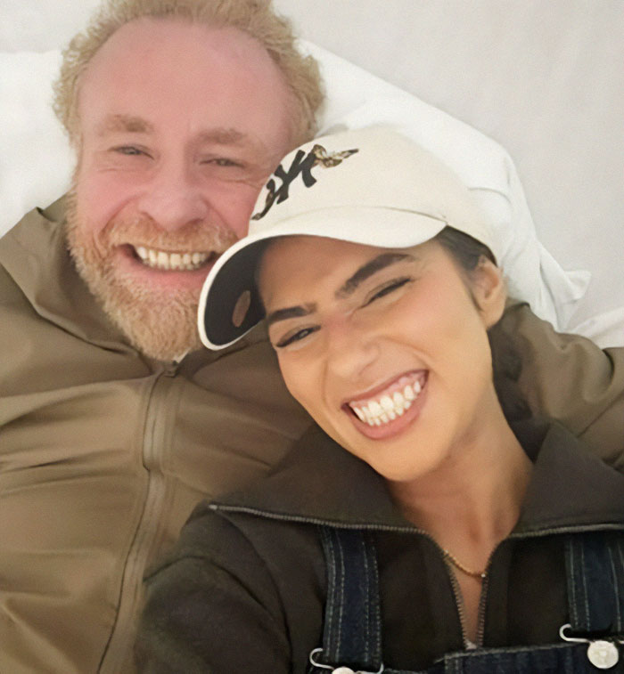 Smiling couple on vacation; man passes away, burial location undisclosed.