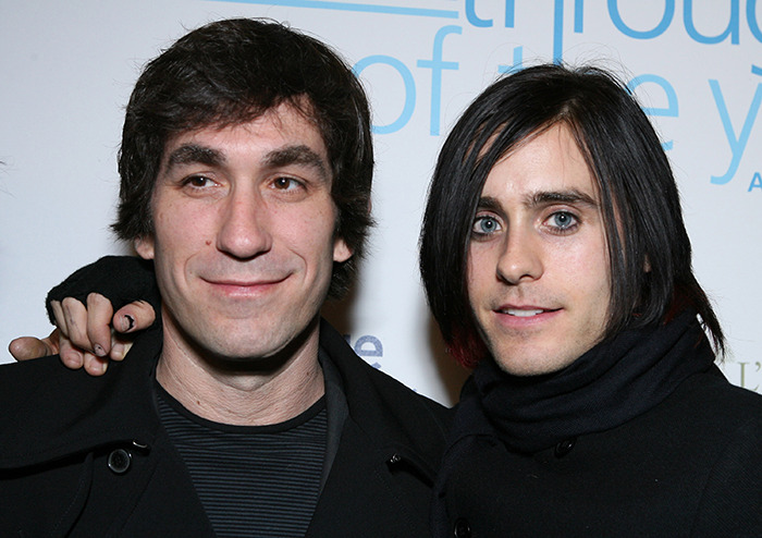 Two men in dark clothing at a public event.
