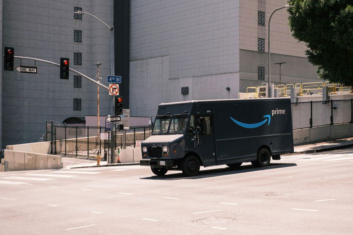 Amazon delivery truck driving on city street, related to heroic delivery driver incident.