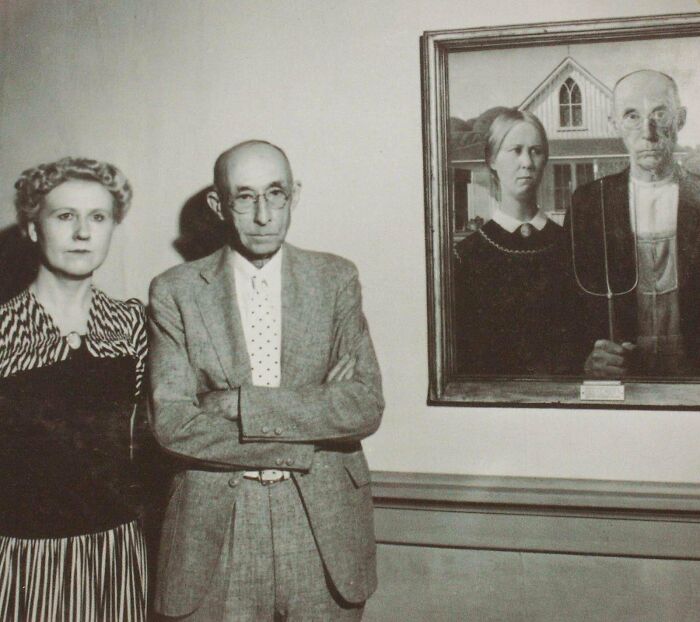 A couple stands next to "American Gothic," an iconic artifact capturing U.S. history in art form.
