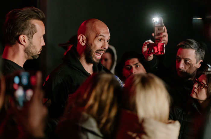 People gathered around Andrew Tate, capturing the moment amid discussions of net worth.