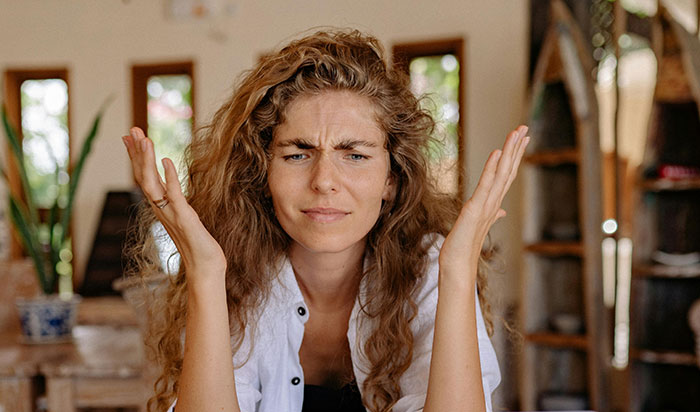 Angry plant owner with raised hands indoors, reacting to plant theft situation.