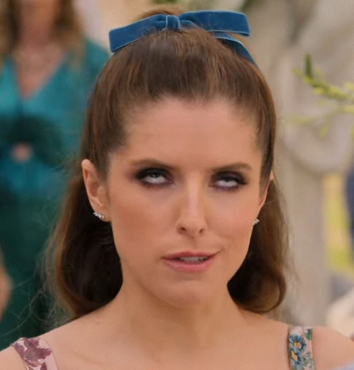 Woman with blue hair bow rolling her eyes, background blurred; related to "spray tan rubbed off" incident.